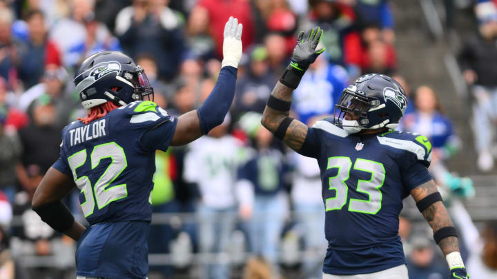 Oct 22, 2023; Seattle, Washington, USA; Seattle Seahawks linebacker Darrell Taylor (52) and safety Jamal Adams (33) celebrate after the defense made a play against the Arizona Cardinals during the first half at Lumen Field. Mandatory Credit: Steven Bisig-USA TODAY Sports