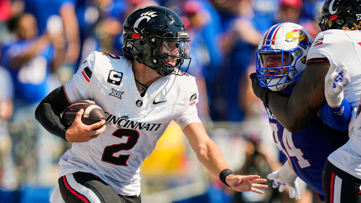 Brendan Sorsby #2 of the Cincinnati Bearcats runs the ball against Blake Herold #94 of the Kansas Jayhawks during the second half at David Booth Kansas Memorial Stadium on September 27, 2025 in Lawrence, Kansas.