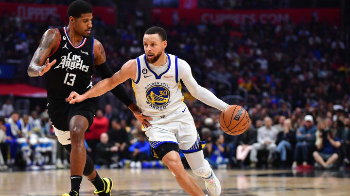 Mar 15, 2023; Los Angeles, California, USA; Golden State Warriors guard Stephen Curry (30) moves the ball against Los Angeles Clippers forward Paul George (13) during the first half at Crypto.com Arena. 