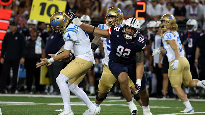 Nov 4, 2023; Tucson, Arizona, USA; Arizona Wildcats defensive lineman Tyler Manoa #92 hits UCLA Bruins quarterback Ethan Garbers #4 as the pass comes back to him during the second half at Arizona Stadium. Mandatory Credit: Zachary BonDurant-Imagn Images