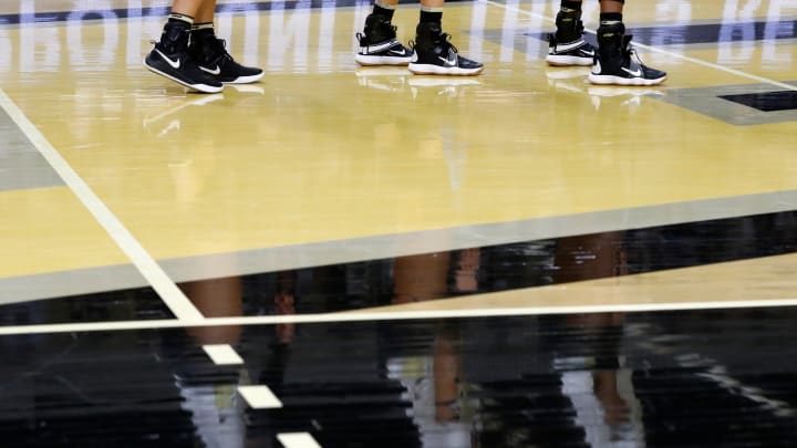 Purdue Boilermakers line up to defend a serve during a match