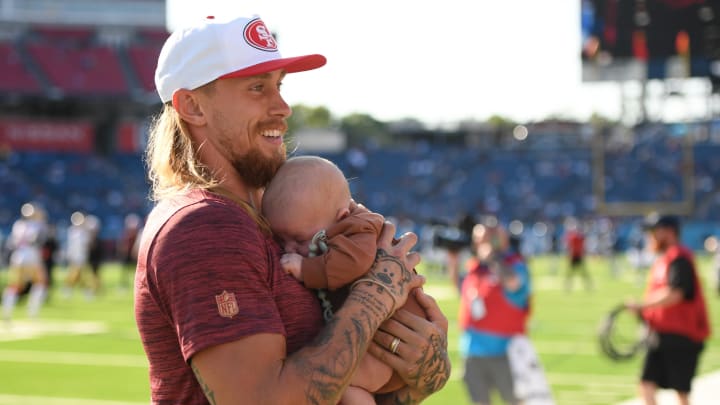 49ers tight end George Kittle shows off his son to the fans during a preseason game against the Titans at Nissan Stadium.