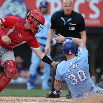 Sep 8, 2024; Arlington, Texas, USA; Los Angeles Angels catcher Matt Thaiss (21) tags out Texas Rangers first base Nathaniel Lowe (30) at home in the eighth inning at Globe Life Field. Mandatory Credit: Tim Heitman-Imagn Images