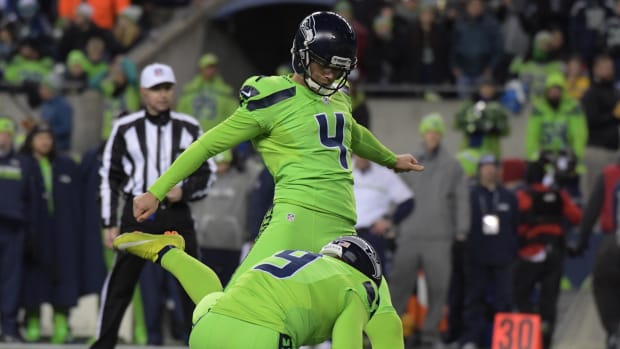 Seattle Seahawks kicker Steven Hauschka (4) kicks an extra point out of the hold of Jon Ryan (9) during an NFL game.