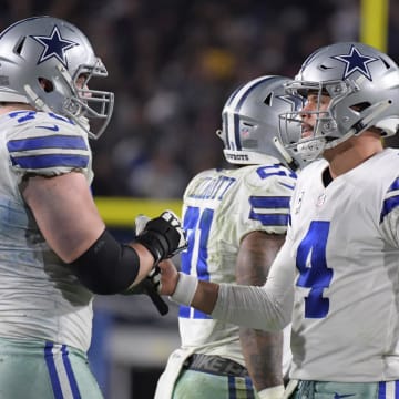 Dallas Cowboys quarterback Dak Prescott (4) and Dallas Cowboys offensive guard Zack Martin (70) react after a play in the second half against the Los Angeles Rams in a NFC Divisional playoff football game at Los Angeles Memorial Stadium. Mandatory Credit: Kirby Lee-USA TODAY Sports