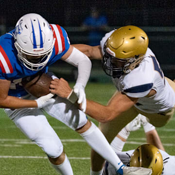 Churchill running back Blake Mikel, left, breaks a tackle by Marist Catholic linebacker Brody Buzzard as the Churchill Lancers host the Marist Catholic Spartans on Aug. 29, 2025, at Churchill High School in Eugene, Oregon.