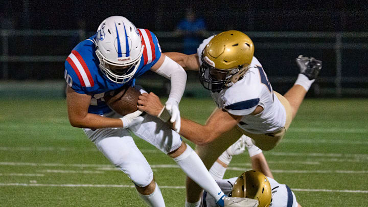 Churchill running back Blake Mikel, left, breaks a tackle by Marist Catholic linebacker Brody Buzzard as the Churchill Lancers host the Marist Catholic Spartans on Aug. 29, 2025, at Churchill High School in Eugene, Oregon. Churchill running back Blake Mikel, left, breaks a tackle by Marist Catholic linebacker Brody Buzzard as the Churchill Lancers host the Marist Catholic Spartans on Aug. 29, 2025, at Churchill High School in Eugene, Oregon.