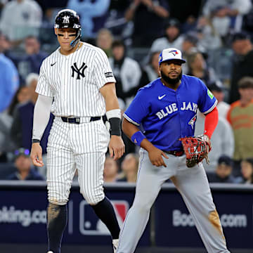 Oct 8, 2025; Bronx, New York, USA; New York Yankees right fielder Aaron Judge (99) stands on first base with Toronto Blue Jays first baseman Vladimir Guerrero Jr. (27) during the ninth inning during game four of the ALDS round for the 2025 MLB playoffs at Yankee Stadium. Mandatory Credit: Brad Penner-Imagn Images