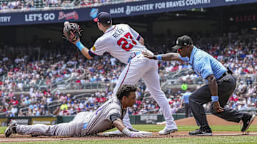 Jun 15, 2025; Cumberland, Georgia, USA; Colorado Rockies shortstop Ryan Ritter (8) slides under third baseman Austin Riley (27) after a throwing error by Atlanta Braves starting pitcher Grant Holmes (66) (not shown) during the third inning at Truist Park. Mandatory Credit: Dale Zanine-Imagn Images