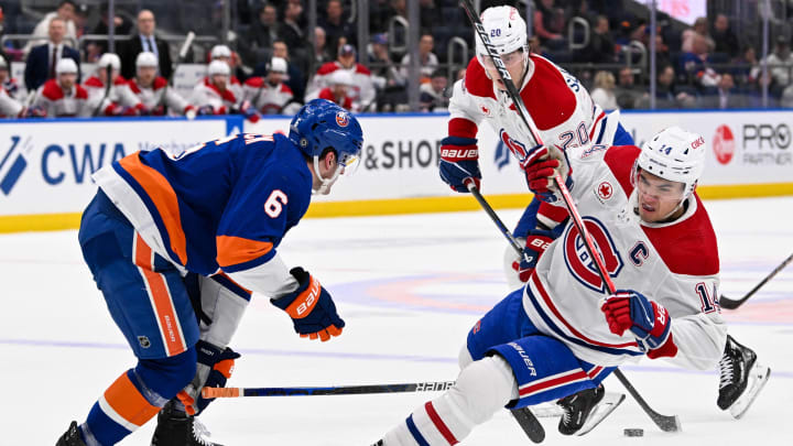 Apr 11, 2024; Elmont, New York, USA; New York Islanders defenseman Ryan Pulock (6) checks Montreal Canadiens center Nick Suzuki (14) during the first period at UBS Arena. Mandatory Credit: Dennis Schneidler-USA TODAY Sports