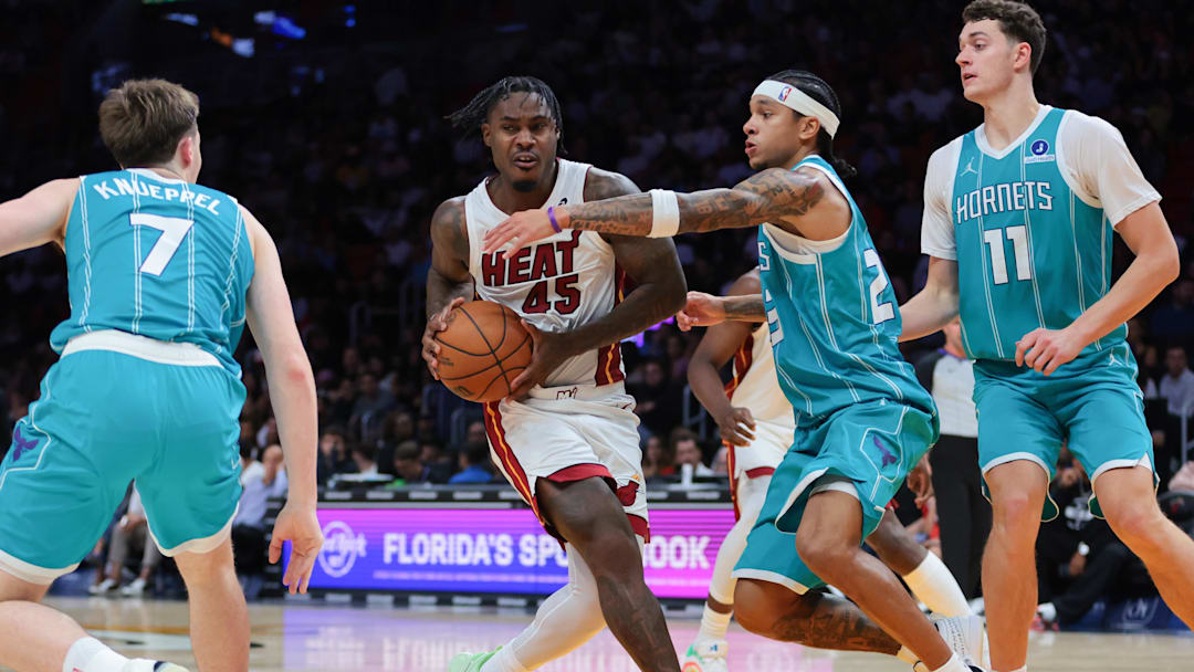 Oct 28, 2025; Miami, Florida, USA; Miami Heat guard Davion Mitchell (45) drives to the basket against Charlotte Hornets guard Tre Mann (23) during the fourth quarter at Kaseya Center. Mandatory Credit: Sam Navarro-Imagn Images