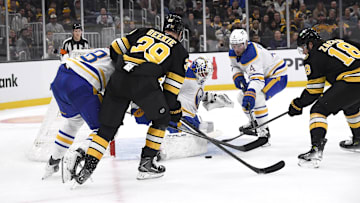 Oct 30, 2025; Boston, Massachusetts, USA; Buffalo Sabres goaltender Alex Lyon (34) makes a save in front of Boston Bruins center Morgan Geekie (39) and defenseman Bowen Byram (4) during the first period at TD Garden. Mandatory Credit: Bob DeChiara-Imagn Images