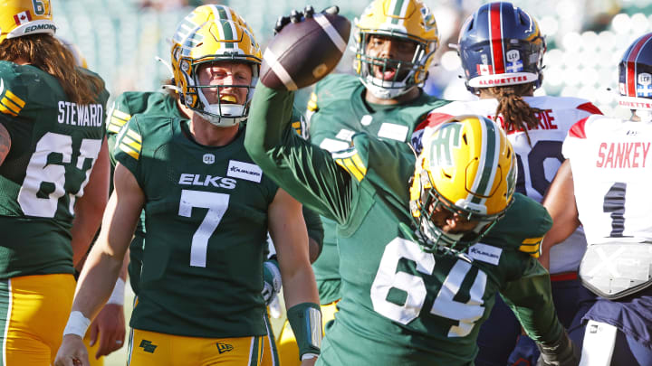 Jun 14, 2024; Edmonton, Alberta, CAN; Edmonton Elks offensive lineman Tomas Jack-Kurdyla (64) splices the ball after a touchdown by quarterback Dakota Prukop (7) during the first half against the Montreal Alouettes at Commonwealth Stadium. Mandatory Credit: Perry Nelson-USA TODAY Sports