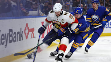 Oct 28, 2024; Buffalo, New York, USA;  Florida Panthers center Aleksander Barkov (16) looks to control the puck as Buffalo Sabres defenseman Bowen Byram (4) defends during the first period at KeyBank Center. Mandatory Credit: Timothy T. Ludwig-Imagn Images