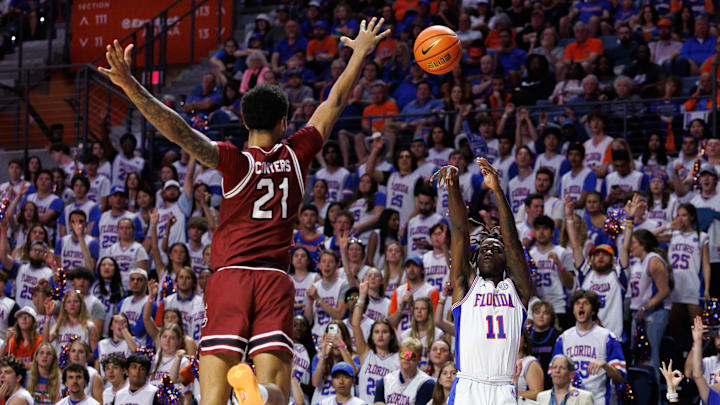 Feb 15, 2025; Gainesville, Florida, USA; Florida Gators guard Denzel Aberdeen (11) makes a three-point basket over South Carolina Gamecocks guard Arden Conyers (21) during the second half at Exactech Arena at the Stephen C. O'Connell Center. Mandatory Credit: Matt Pendleton-Imagn Images