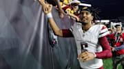 Washington Commanders quarterback Jayden Daniels celebrates with fans following the win against the Cincinnati Bengals.