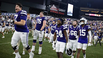 Dec 26, 2024; Phoenix, AZ, USA; Kansas State Wildcats offensive lineman Logan Cox (67) celebrates with running back JB Price (24) and wide receiver Trae Davis (15) after defeating the Rutgers Scarlet Knights during the Rate Bowl at Chase Field. Mandatory Credit: Mark J. Rebilas-Imagn Images