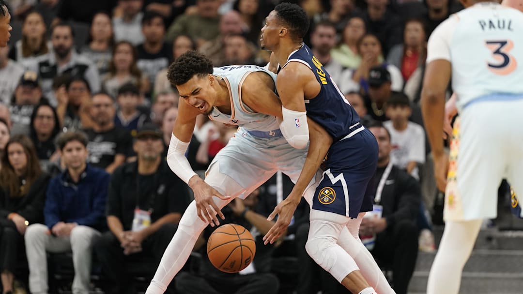 Jan 4, 2025; San Antonio, Texas, USA; Denver Nuggets guard Russell Westbrook (4) commits a foul against San Antonio Spurs center Victor Wembanyama (1) during the second half at Frost Bank Center.