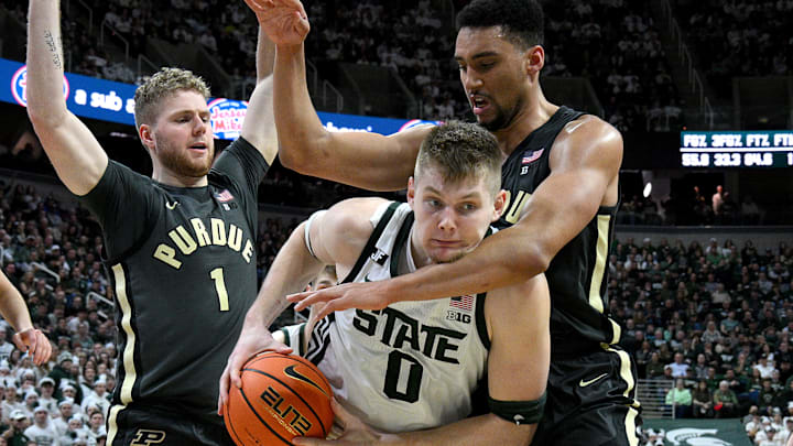 Feb 18, 2025; East Lansing, Michigan, USA;  Michigan State Spartans forward Jaxon Kohler (0) controls a rebound against Purdue Boilermakers forward Trey Kaufman-Renn (4) and forward Caleb Furst (1) during the second half at Jack Breslin Student Events Center. Mandatory Credit: Dale Young-Imagn Images