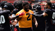 Cincinnati Bearcats defensive tackle Dontay Corleone (2) embraces his teammates during a scrimmage, Saturday, Aug. 10, 2024, at Nippert Stadium in Cincinnati.