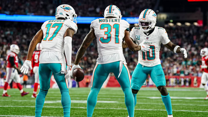  Miami Dolphins running back Raheem Mostert (31) celebrates with wide receiver Tyreek Hill (10) and wide receiver Jaylen Waddle (17) after scoring against the New England Patriots in the second quarter at Gillette Stadium in 2023.