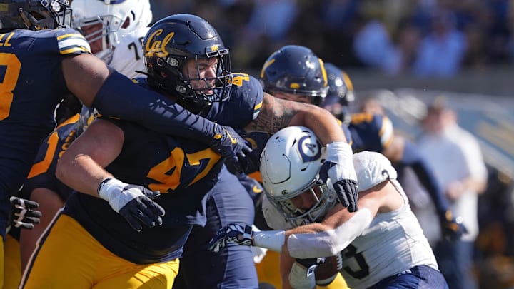  Aidan Keanaaina tackles UC Davis running back Lan Larison.