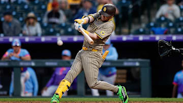 May 9, 2025; Denver, Colorado, USA; San Diego Padres second baseman Jake Cronenworth (9) hits into a fielders choice RBI on a throwing error from the Colorado Rockies in the fifth inning at Coors Field. Mandatory Credit: Isaiah J. Downing-Imagn Images