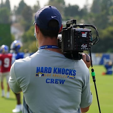 An HBO Hard Knocks cameraman shoots video footage at Los Angeles Rams training camp practice.
