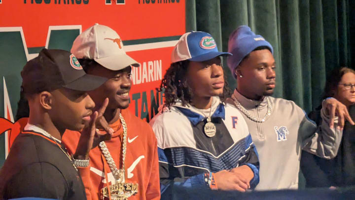 Mandarin quarterback Tramell Jones Jr. (Florida), wide receiver Jaime Ffrench Jr. (Texas), safety Hylton (Drake) Stubbs (Florida) and defensive back Jaylen Lewis (Memphis) celebrate their college football signings on Dec. 4, 2024. [Clayton Freeman/Florida Times-Union]
