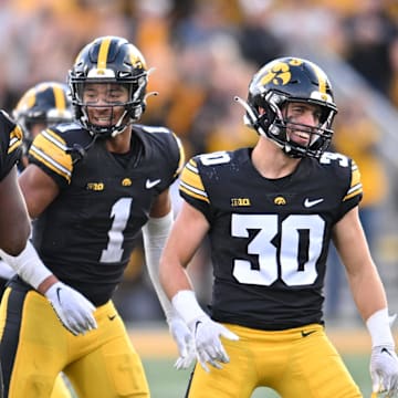 Oct 7, 2023; Iowa City, Iowa, USA; Iowa Hawkeyes linebacker Jay Higgins (34) and defensive back Xavier Nwankpa (1) and defensive back Quinn Schulte (30) react after an interception by Higgins against the Purdue Boilermakers during the fourth quarter at Kinnick Stadium.  