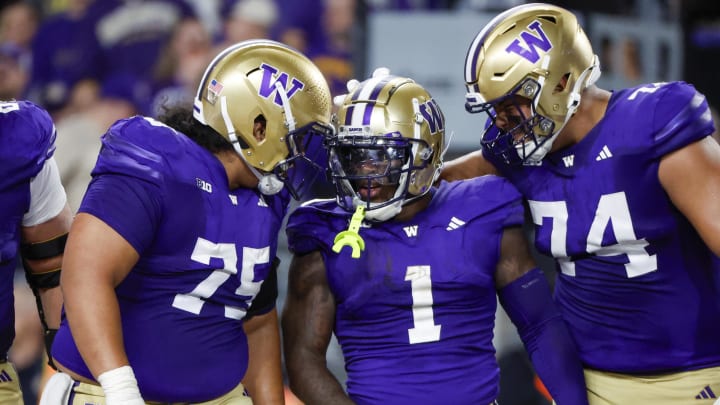 Offensive linemen D'Angalo Titialii (75) and Drew Azzopardi (74) bookend Jonah Coleman after he scored one of his 3 TDs against Weber State. 