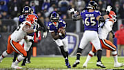 Jan 4, 2025; Baltimore, Maryland, USA; Baltimore Ravens quarterback Lamar Jackson (8) controls the ball as Cleveland Browns defensive end Myles Garrett (95) defends during the first quarter at M&T Bank Stadium. Mandatory Credit: Tommy Gilligan-Imagn Images