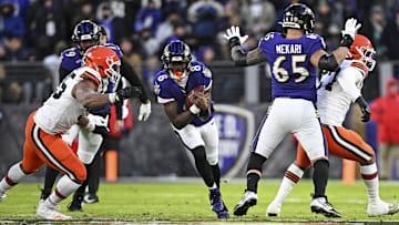Jan 4, 2025; Baltimore, Maryland, USA; Baltimore Ravens quarterback Lamar Jackson (8) controls the ball as Cleveland Browns defensive end Myles Garrett (95) defends during the first quarter at M&T Bank Stadium. Mandatory Credit: Tommy Gilligan-Imagn Images