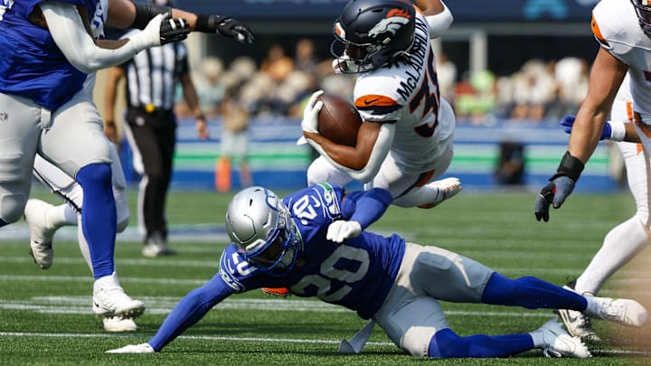 Sep 8, 2024; Seattle, Washington, USA; Seattle Seahawks safety Julian Love (20) tackles Denver Broncos running back Jaleel McLaughlin (38) during the second quarter at Lumen Field.