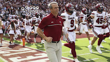 Nov 15, 2025; College Station, Texas, USA; South Carolina Gamecocks head coach Shane Beamer runs onto the field with players before the game against the Texas A&M Aggies at Kyle Field. Mandatory Credit: Troy Taormina-Imagn Images
