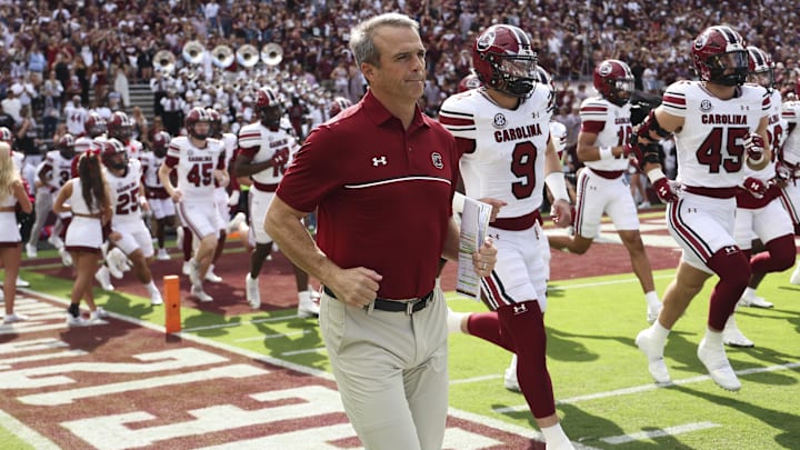 Nov 15, 2025; College Station, Texas, USA; South Carolina Gamecocks head coach Shane Beamer runs onto the field with players before the game against the Texas A&M Aggies at Kyle Field. Mandatory Credit: Troy Taormina-Imagn Images