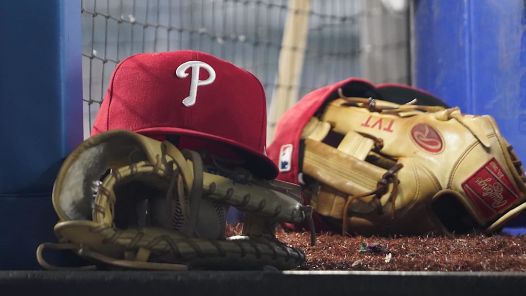 Aug 16, 2023; Toronto, Ontario, CAN; A Philadelphia Phillies cap and glove sit in the dugout during a game against the Toronto Blue Jays at Rogers Centre. 