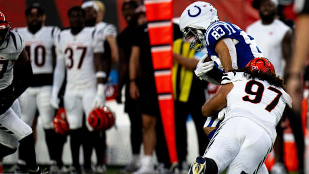 Colts tight end Kylen Granson (blue jersey; white Guardian cap) gets tackled after a catch by a defender. 