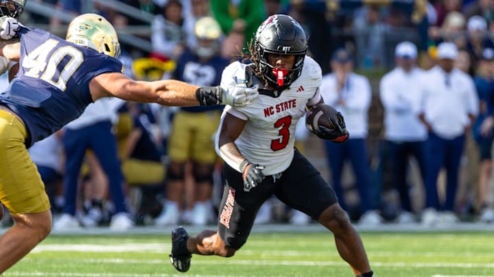 Oct 11, 2025; South Bend, Indiana, USA; NC State Wolfpack running back Hollywood Smothers (3) tries to break a tackle attempt by Notre Dame Fighting Irish linebacker Joshua Burnham (40) during the first half at Notre Dame Stadium. Mandatory Credit: Michael Caterina-Imagn Images