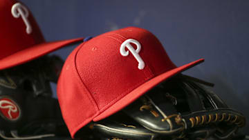 Detailed view of a Philadelphia Phillies hat and glove in the dugout