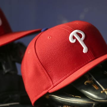 May 25, 2022; Atlanta, Georgia, USA; Detailed view of a Philadelphia Phillies hat and glove in the dugout against the Atlanta Braves in the eighth inning at Truist Park. Mandatory Credit: Brett Davis-Imagn Images