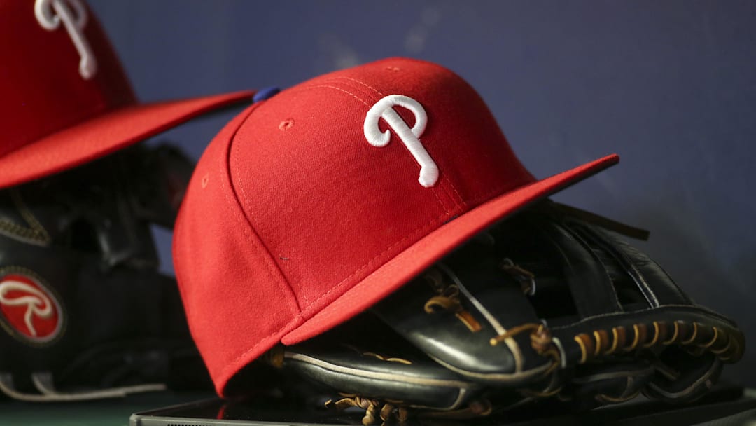May 25, 2022; Atlanta, Georgia, USA; Detailed view of a Philadelphia Phillies hat and glove in the dugout against the Atlanta Braves in the eighth inning at Truist Park. Mandatory Credit: Brett Davis-Imagn Images