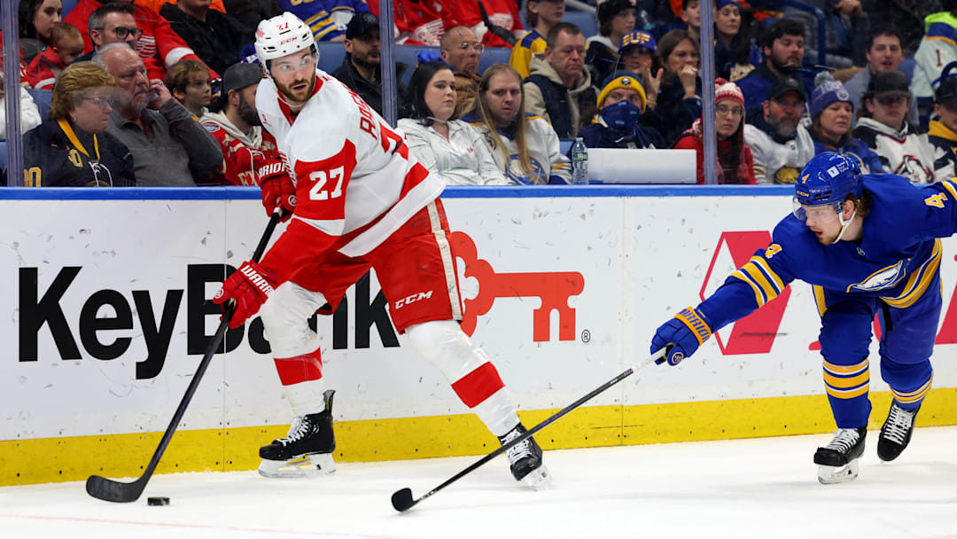 Dec 9, 2024; Buffalo, New York, USA;  Detroit Red Wings center Michael Rasmussen (27) looks to make a pass as Buffalo Sabres defenseman Bowen Byram (4) defends during the first period at KeyBank Center. Mandatory Credit: Timothy T. Ludwig-Imagn Images