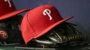 May 25, 2022; Atlanta, Georgia, USA; Detailed view of a Philadelphia Phillies hat and glove in the dugout against the Atlanta Braves in the eighth inning at Truist Park.