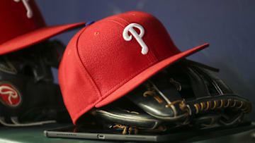 May 25, 2022; Atlanta, Georgia, USA; Detailed view of a Philadelphia Phillies hat and glove in the dugout against the Atlanta Braves in the eighth inning at Truist Park.