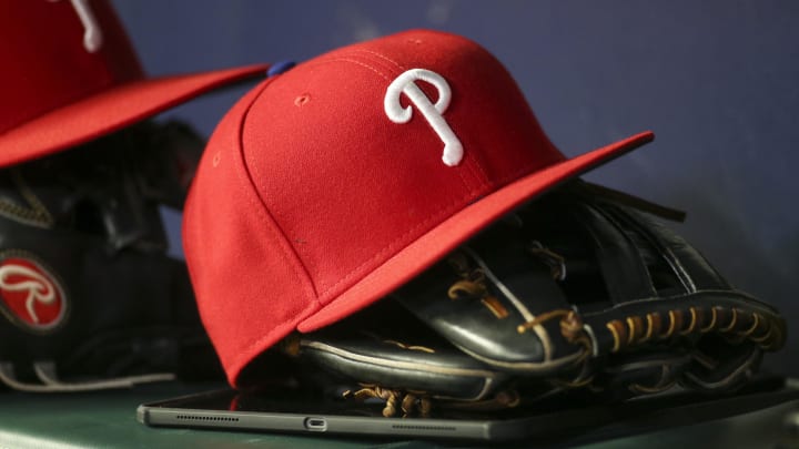 May 25, 2022; Atlanta, Georgia, USA; Detailed view of a Philadelphia Phillies hat and glove in the dugout against the Atlanta Braves in the eighth inning at Truist Park.