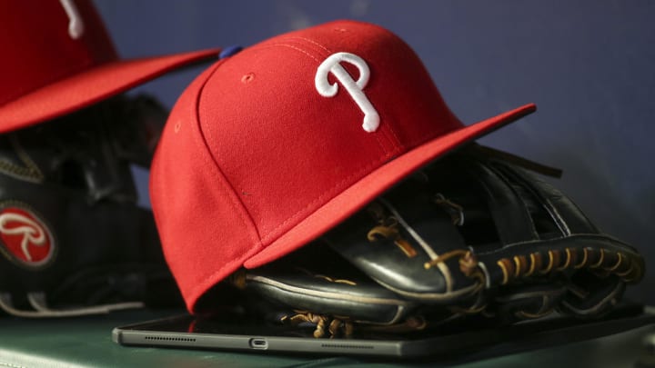 May 25, 2022; Atlanta, Georgia, USA; Detailed view of a Philadelphia Phillies hat and glove in the dugout against the Atlanta Braves in the eighth inning at Truist Park. 