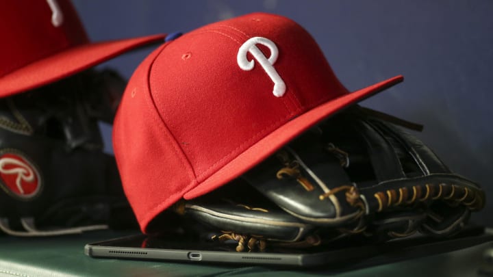 Detailed view of a Philadelphia Phillies hat and glove in the dugout