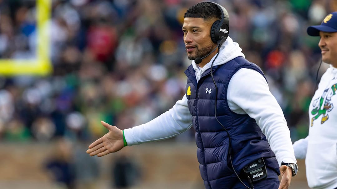 Nov 22, 2025; South Bend, Indiana, USA; Notre Dame Fighting Irish head coach Marcus Freeman celebrates with players after scoring against the Syracuse Orange during the first half at Notre Dame Stadium. 