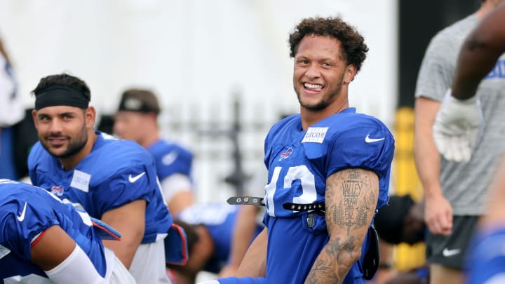 Linebacker Terrel Bernard shares a laugh with Matt Milano while stretching before a training camp practice.